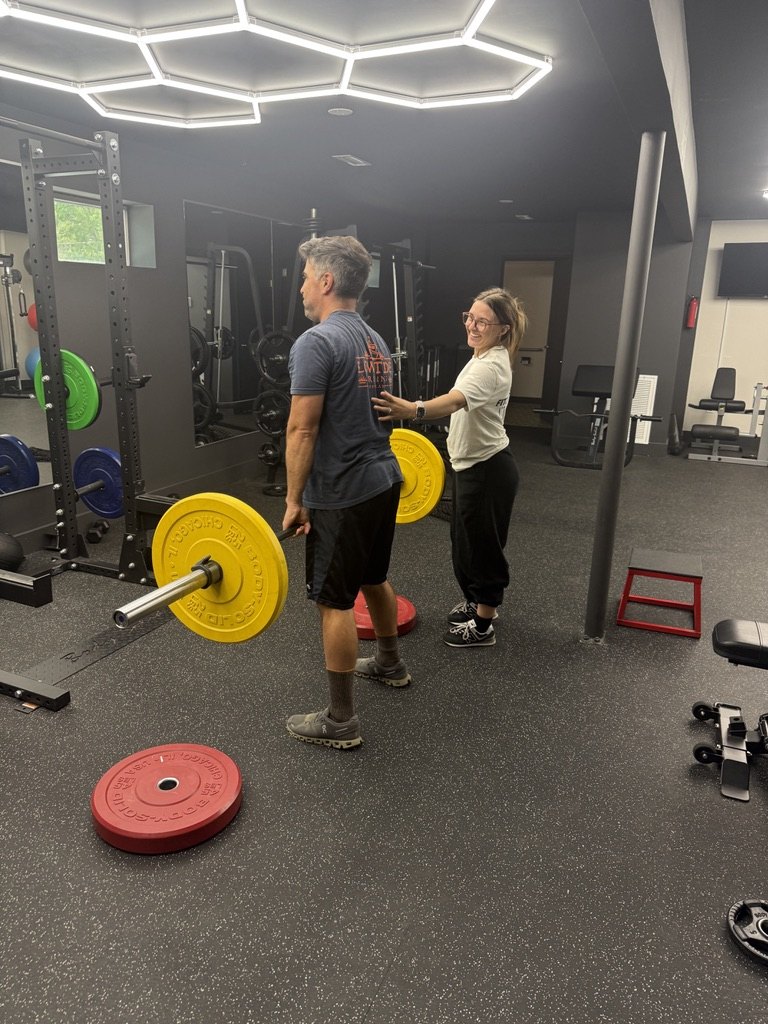 A Fitz Fitness trainer setting up a barbell with a client during a one-on-one session on Johns Island