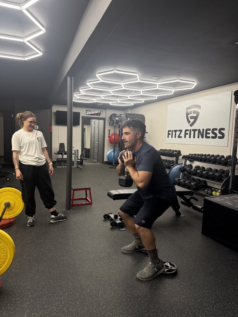 A Fitz Fitness trainer and client performing goblet squats together during a partner training session
